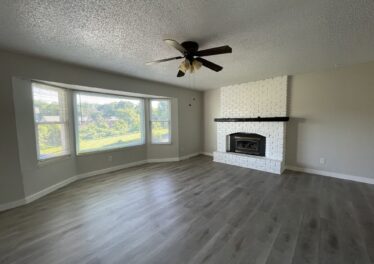 Living room with hardwoods, window and fireplace